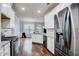 Modern kitchen with white cabinets, granite countertops, stainless steel appliances, and hardwood flooring at 7933 Heathmore Dr, Fairburn, GA 30213