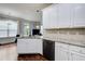Stylish kitchen featuring granite countertops, black appliances, and white cabinetry at 7933 Heathmore Dr, Fairburn, GA 30213