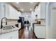Stylish kitchen with white cabinets, granite counters, stainless steel appliances, and an open view to the dining area at 7933 Heathmore Dr, Fairburn, GA 30213