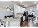 Open-concept kitchen with granite island, white cabinetry, stainless steel appliances, and hardwood floors at 7933 Heathmore Dr, Fairburn, GA 30213
