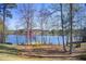 Peaceful lake view featuring mature trees, benches and a glimpse of neighborhood homes at 7933 Heathmore Dr, Fairburn, GA 30213