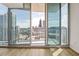 Condo balcony features a cityscape view, wood floors, and sliding glass doors at 860 Peachtree Ne St # 2209, Atlanta, GA 30308
