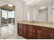 Bathroom featuring a vanity with stone countertops, wood cabinets, a large mirror, and city views at 860 Peachtree Ne St # 2209, Atlanta, GA 30308
