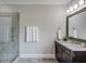 Tiled bathroom features a glass enclosed shower, granite counters, and vanity with modern fixtures at 1074 Nash Springs Cir, Lilburn, GA 30047