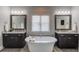 Bright bathroom features a soaking tub, granite counters, dual sinks, and decorative mirrors at 1074 Nash Springs Cir, Lilburn, GA 30047