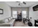 Neutral bedroom with an electric drum set, gray couch and ceiling fan at 1074 Nash Springs Cir, Lilburn, GA 30047