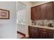 Convenient butler's pantry with granite countertops, mosaic tile backsplash, and custom cabinetry at 1074 Nash Springs Cir, Lilburn, GA 30047