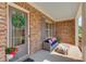 Inviting front porch with brick facade, outdoor seating, and a decorative wreath on the front door at 1074 Nash Springs Cir, Lilburn, GA 30047
