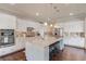 A gourmet kitchen with white cabinets, a large granite island with seating, and stainless steel appliances at 1074 Nash Springs Cir, Lilburn, GA 30047