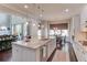Open concept kitchen with granite island and stainless steel appliances, flowing seamlessly into a cozy living area and dining space at 1074 Nash Springs Cir, Lilburn, GA 30047