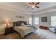 Comfortable main bedroom features a ceiling fan, tray ceiling, and neutral decor at 1074 Nash Springs Cir, Lilburn, GA 30047