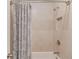 Shower/tub combination features tile walls, updated fixtures, and a decorative shower curtain at 1074 Nash Springs Cir, Lilburn, GA 30047