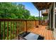 Inviting wooden balcony featuring outdoor seating and a glass table with a view of lush trees at 1635 Briarcliff Rd # 8, Atlanta, GA 30306