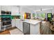 A kitchen with stainless steel appliances, white cabinets and countertops, and an emerald backsplash, open to the living room at 1635 Briarcliff Rd # 8, Atlanta, GA 30306