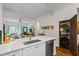 A kitchen featuring stainless steel appliances, white cabinets and countertops, and an emerald backsplash, open to the living room at 1635 Briarcliff Rd # 8, Atlanta, GA 30306