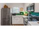Bright kitchen with stainless steel appliances, white cabinets, green tile backsplash, and a window at 1635 Briarcliff Rd # 8, Atlanta, GA 30306