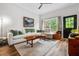 Living room with a large sofa, area rug, coffee table, black door, and a window to the outdoors at 1635 Briarcliff Rd # 8, Atlanta, GA 30306