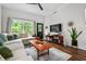 A stylish living room with a comfortable sofa, area rug, coffee table, and a view of the outside through a window at 1635 Briarcliff Rd # 8, Atlanta, GA 30306