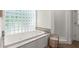 Bathroom with a soaking tub, separate shower and natural light from a glass block window at 3818 Sweet Bottom Dr, Duluth, GA 30096