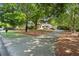 Home exterior with mature trees, manicured lawn, and a long concrete driveway at 3818 Sweet Bottom Dr, Duluth, GA 30096