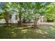 Charming white home with classic windows, surrounded by lush greenery and a well-maintained lawn at 3818 Sweet Bottom Dr, Duluth, GA 30096