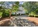 Stately home with white columns, black shutters, and a circular driveway surrounded by lush landscaping at 3818 Sweet Bottom Dr, Duluth, GA 30096