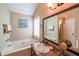 Bathroom featuring a soaking tub, vanity with granite counters, and a decorative mirror at 4872 Nature Trl, Austell, GA 30106