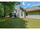 Exterior view showcases the backyard, featuring a wooden fence, mature trees, and the side of the house with a chimney at 4872 Nature Trl, Austell, GA 30106
