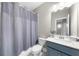 Bathroom featuring a shower with gray curtain, toilet, vanity, and mirror at 1381 Wallace Walk, Atlanta, GA 30316
