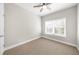 Bedroom features a ceiling fan, window with blinds, and neutral carpet at 1381 Wallace Walk, Atlanta, GA 30316