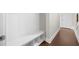 Hallway featuring built in bench with storage underneath along a wall with base trim and wood floors at 1381 Wallace Walk, Atlanta, GA 30316