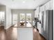 Open-concept kitchen boasts stainless appliances, a granite island, and natural light with door to balcony at 1381 Wallace Walk, Atlanta, GA 30316