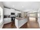 Open kitchen with white cabinets, stainless steel appliances, and granite island overlooking living area at 1381 Wallace Walk, Atlanta, GA 30316