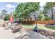 Inviting backyard featuring a patio, lush green grass, a basketball hoop, and mature trees at 1563 Country Wood Dr, Hoschton, GA 30548