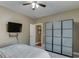 This bedroom has a ceiling fan, a wall-mounted TV, and a door leading to another room at 1563 Country Wood Dr, Hoschton, GA 30548