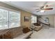 Comfortable bonus room with large windows, neutral carpet, ceiling fan, and sofa for relaxing at 1563 Country Wood Dr, Hoschton, GA 30548