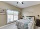 Comfortable bedroom featuring neutral tones, a ceiling fan, and a window with natural light at 1563 Country Wood Dr, Hoschton, GA 30548