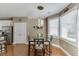 Breakfast nook featuring modern lighting fixture, wood floors, and lots of natural light from the large window at 1563 Country Wood Dr, Hoschton, GA 30548