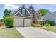 Spacious two-story home with a two-car garage, brick accents, and well-kept lawn at 1563 Country Wood Dr, Hoschton, GA 30548