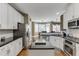 Bright kitchen with white cabinets, stainless appliances, granite countertops, a kitchen island and pendant lighting at 1563 Country Wood Dr, Hoschton, GA 30548