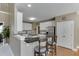 Kitchen featuring bar seating, stainless steel appliances, white cabinets, and granite counters at 1563 Country Wood Dr, Hoschton, GA 30548