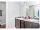 Bathroom featuring a double sink vanity, framed mirror, and toilet under colorful towel racks at 2470 Day Break Way, Dacula, GA 30019