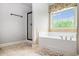 Bright bathroom featuring a standalone tub, shower stall, and bright window at 2470 Day Break Way, Dacula, GA 30019