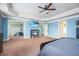 Spacious bedroom with blue walls, tray ceiling, TV, and adjoining exercise room at 2470 Day Break Way, Dacula, GA 30019