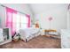 Bright bedroom with carpet, a window with pink curtains, a small desk, and a well-lit interior at 2470 Day Break Way, Dacula, GA 30019