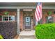 Inviting front entrance with American flag, floral accents, and manicured bushes at 2470 Day Break Way, Dacula, GA 30019