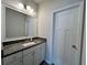 Granite countertop bathroom vanity, framed mirror, and a three-panel door for modern convenience at 2506 Monta Vista Way, Hoschton, GA 30548