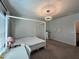 A bedroom features a four-poster bed, natural light, and space for a desk and bookshelf at 2506 Monta Vista Way, Hoschton, GA 30548
