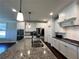 Modern kitchen with granite countertops, stainless steel appliances, and white cabinets, perfect for culinary enthusiasts at 2506 Monta Vista Way, Hoschton, GA 30548