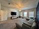 Open living room featuring a large sectional sofa, entertainment center, and natural light from multiple windows at 2506 Monta Vista Way, Hoschton, GA 30548